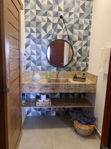 a bathroom with a sink and a mirror at Chalé I - Village da Serra in Serra de São Bento
