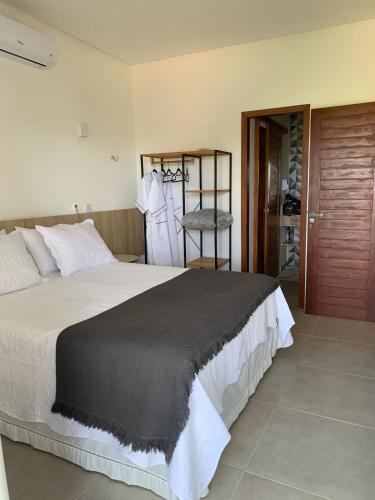 a bedroom with a large bed and a closet at Chalé I - Village da Serra in Serra de São Bento