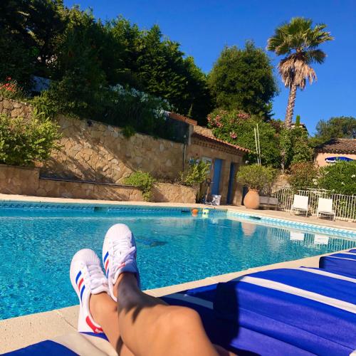 a person laying on the steps next to a swimming pool at Hôtel Jas Neuf in Sainte-Maxime