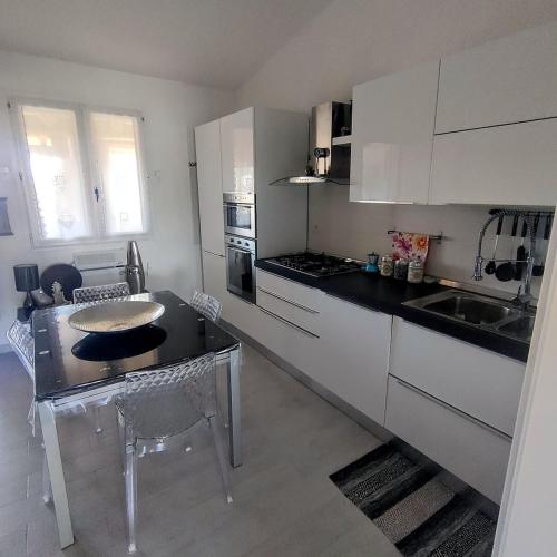 a kitchen with white cabinets and a table and chairs at Perdas Room in Quartu Sant'Elena