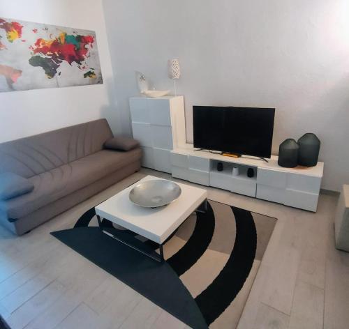 a living room with a couch and a flat screen tv at Perdas Room in Quartu Sant'Elena