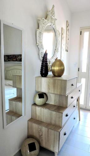 a dresser with a mirror and a vase on it at Perdas Room in Quartu Sant'Elena