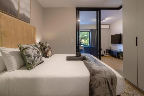 a bedroom with a large white bed with pillows at #AlimamaSpaces The Rob's Akaru in Johannesburg