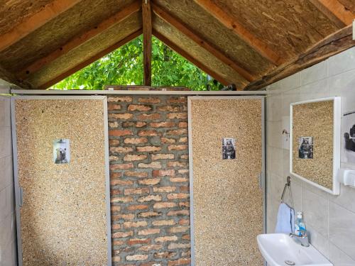 a bathroom with a sink and a stone wall at Seosko domaćinstvo „GABAR” in Ćuštica