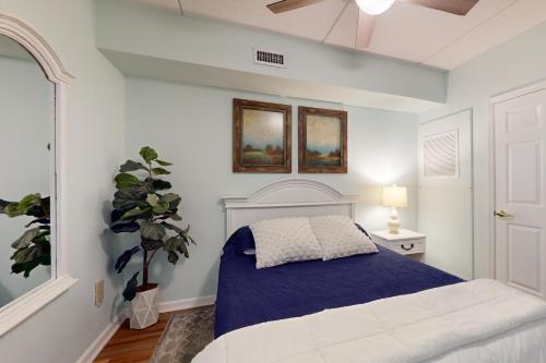 a bedroom with a white bed with a blue blanket at Water Street Condos Unit 310 in Wilmington