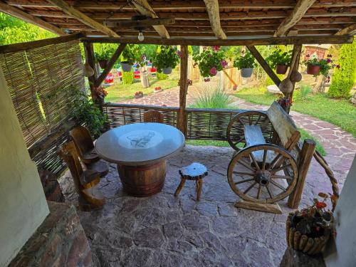 a patio with a wooden table and a wooden wheel at Seosko domaćinstvo „GABAR” in Ćuštica