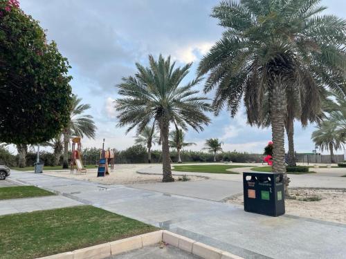 two palm trees in a park with a playground at الدرر البانورامية للعوائل فقط in King Abdullah Economic City