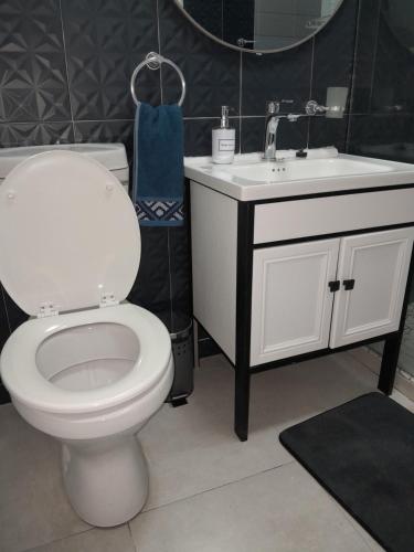 a bathroom with a white toilet and a sink at Acacia House in Lusaka