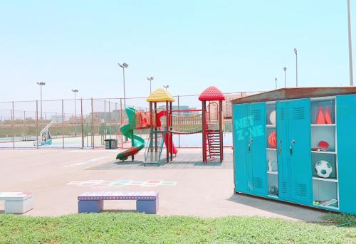 a playground with a slide and a play structure at الدرر البانورامية للعوائل فقط in King Abdullah Economic City
