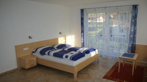 a bedroom with a bed with blue and white pillows at Ferienhaus Wieser in Niedernsill