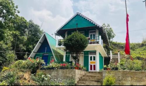 a house with a blue and green roof at Dara Homestay, Charkhole in Kalimpong