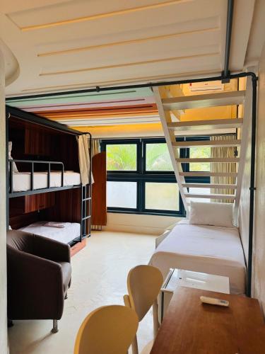 a room with two beds and a couch and a table at Own Búzios Beach Hotel in Búzios