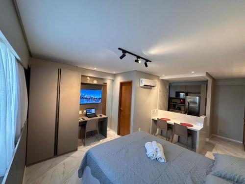 a bedroom with a bed and a desk and a kitchen at Flat localizado a 200m Shopping Recife, bem Perto da Praia de Boa Viagem e com Wi-Fi 400Mbps in Recife