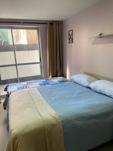 una camera da letto con un letto grande con una finestra di Flat Beira-Mar Cabo Branco a João Pessoa