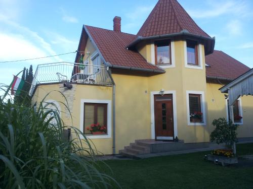 a yellow house with a red roof at Hajas Família Kiadó Szobák in Balatonmáriafürdő