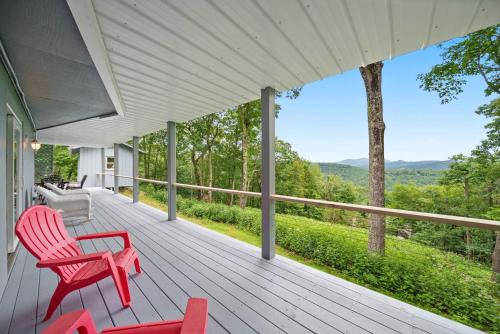 a porch with red chairs and a view of the mountains at Longview Lodge in Boone