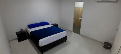 a bedroom with a bed in a white room at Hotel Roy in Santa Marta