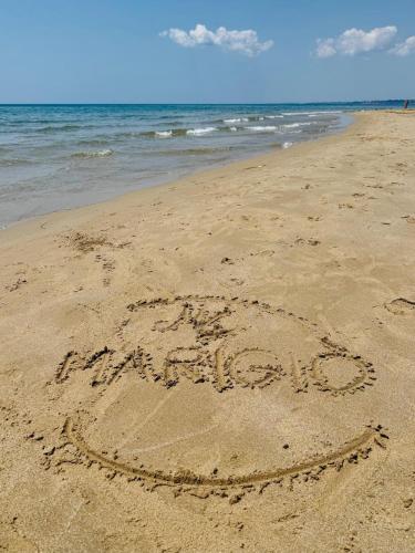 an inscription written in the sand on a beach at Marigiò in Menfi