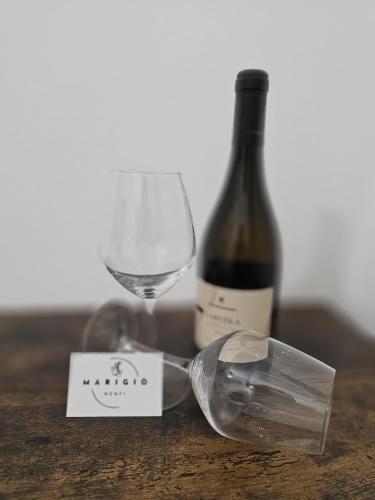 a bottle of wine and a wine glass on a table at Marigiò in Menfi