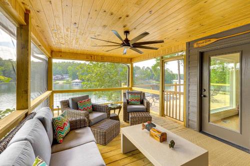 a screened in porch with a couch and a ceiling fan at Arcade Cove - Renovated Lake Martin Home with Dock in Eclectic