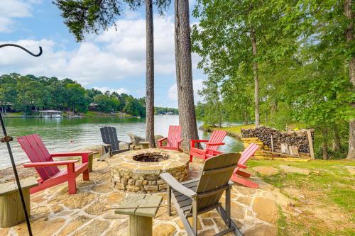 a group of chairs sitting around a fire pit by the water at Arcade Cove - Renovated Lake Martin Home with Dock in Eclectic