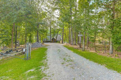 a gravel road with trees and a house in the distance at Arcade Cove - Renovated Lake Martin Home with Dock in Eclectic
