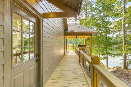 a wooden walkway leading to a house with a door at Arcade Cove - Renovated Lake Martin Home with Dock in Eclectic