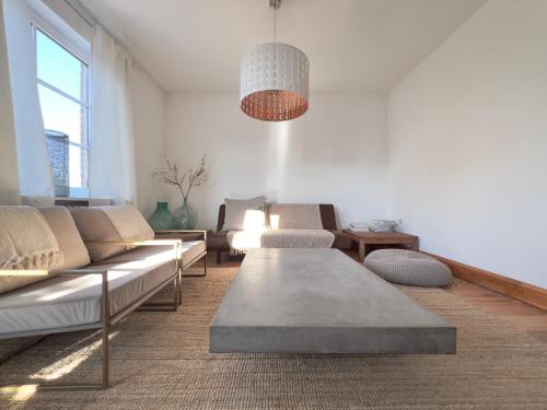 ein Wohnzimmer mit Sofas und einem Tisch in der Unterkunft Wohnung Bel Etage im historischen Amtshaus in Fehmarn