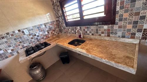 a kitchen counter with a sink and a window at Casa dunna azul in Trairi