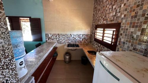 a kitchen with a counter and a stove in it at Casa dunna azul in Trairi