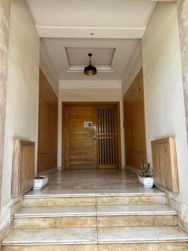 an empty hallway with a wooden door and stairs at Résidence Liyam in Casablanca
