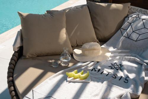 a beach chair with a hat and a tray of fruit at Mitsis Rodos Village in Kiotari