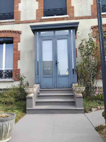 a blue door of a house with stairs at Le jardin de Kristine in Vinneuf