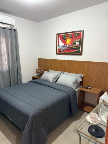 a bedroom with a blue bed and a table at Aurum Hotel in Água Boa
