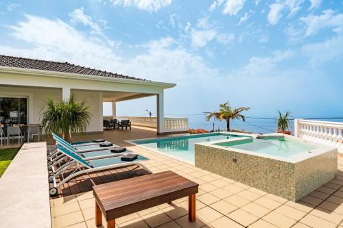 a backyard with a swimming pool and a house at Quinta dos Louros in Estreito da Calheta
