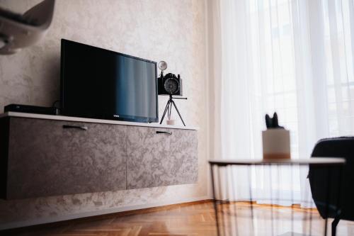 a living room with a flat screen tv on a cabinet at Anamasi in Novi Sad