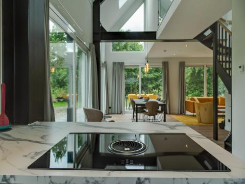 a kitchen with a glass counter top and a living room at Bungalow in Texel near National Park in Westermient