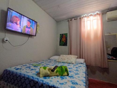 ein Schlafzimmer mit einem Bett und einem Fernseher an der Wand in der Unterkunft Pousada kurasi alter in Alter do Chao