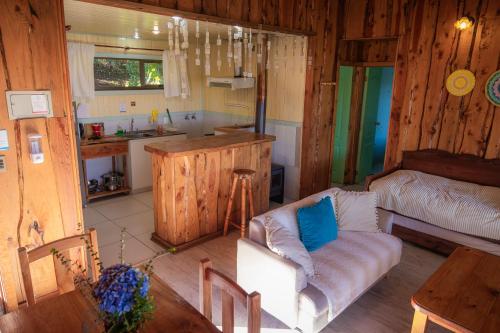 a living room with a couch and a kitchen at Antuquelen Lodge Cabañas in Frutillar