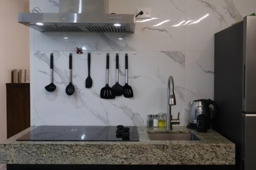 a kitchen counter with utensils hanging on a wall at La Casita in Puerto Peñasco