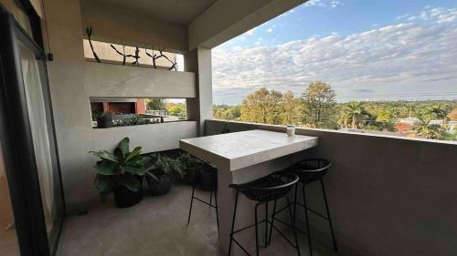 a balcony with a counter and stools and a large window at Modern 265m2 Flat BBQ Pool Gym in Asuncion