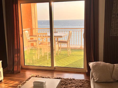 a living room with a table and a view of the ocean at الدرر البانورامية للعوائل فقط in King Abdullah Economic City