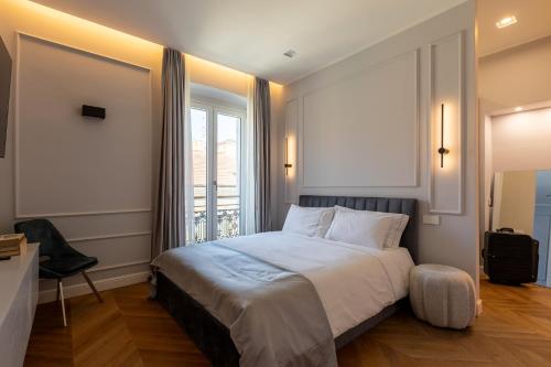 een slaapkamer met een groot bed en een raam bij Twins Boutique Apartments in Sanremo