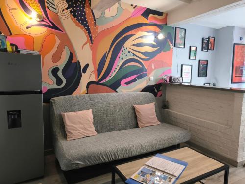 a living room with a couch and a colorful wall at LE MADISON, Gîte Atypique - NETFLIX in Dieppe