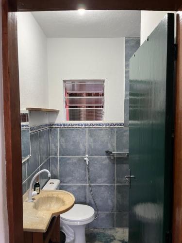 a bathroom with a toilet and a sink at Casa com Vista para o Mar no Coração de Ilhabela in Ilhabela