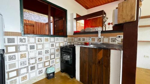 a kitchen with a stove and a sink at Casa com Vista para o Mar no Coração de Ilhabela in Ilhabela