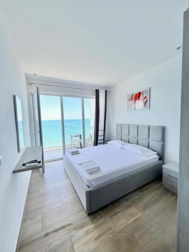 a bedroom with a bed and a view of the ocean at Megi's apartment in Shëngjin