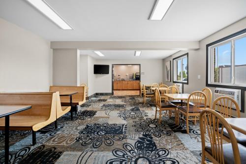 a dining room with tables and chairs and a tv at Fargo Inn and Suites in Fargo