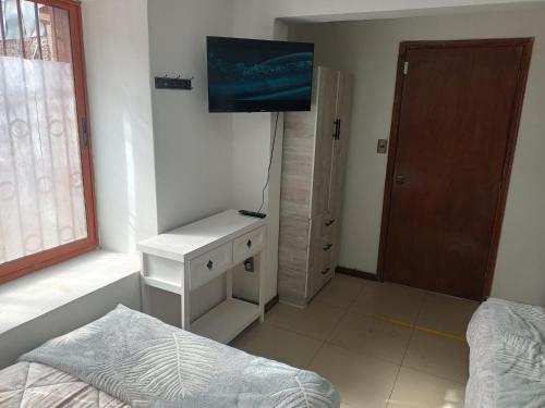 a bedroom with a bed and a tv on the wall at Hostal O'Higgins in Los Andes