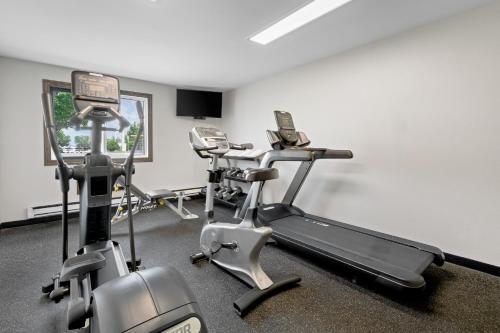 a gym with three exercise bikes in a room at Fargo Inn and Suites in Fargo
